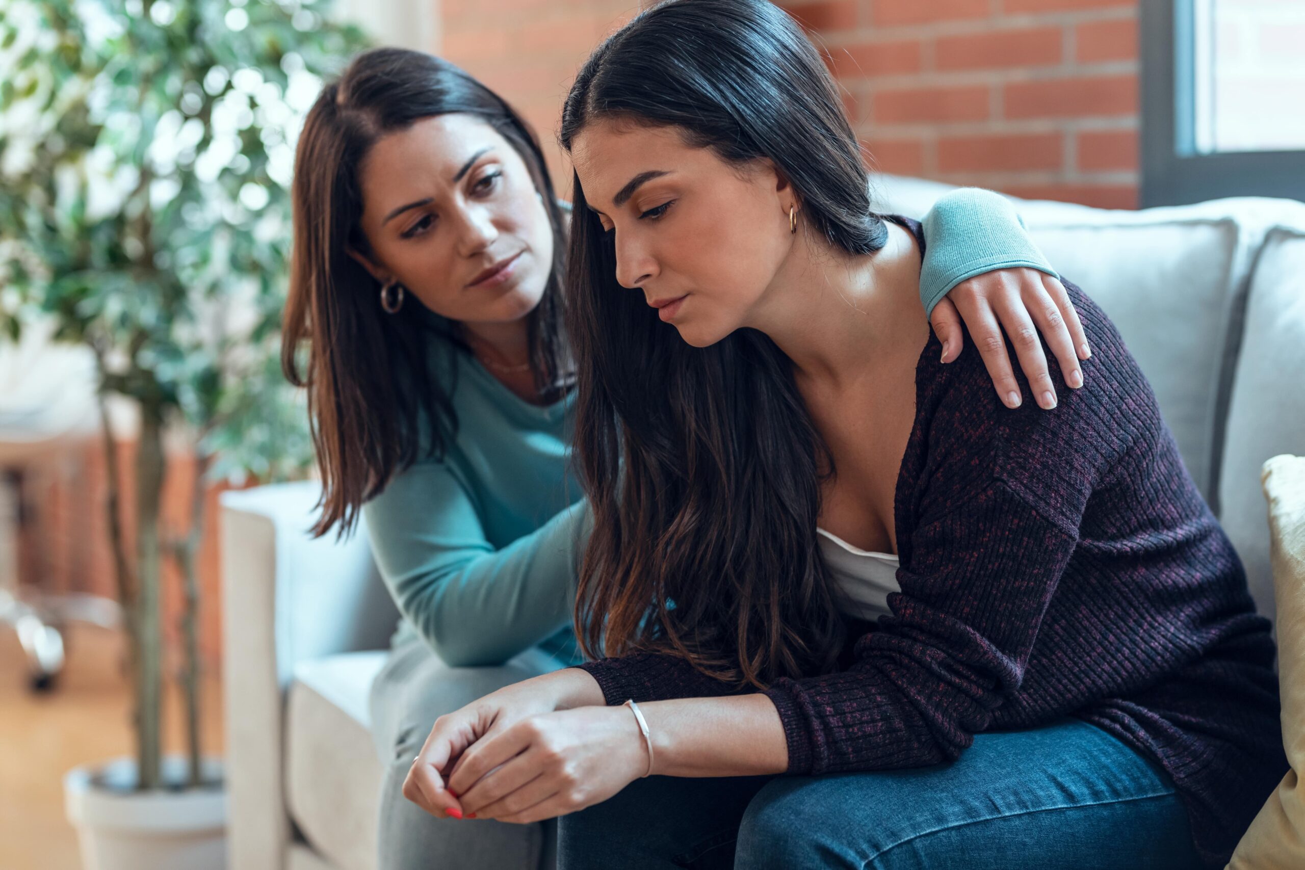 Woman supporting a young adult struggling with depression.