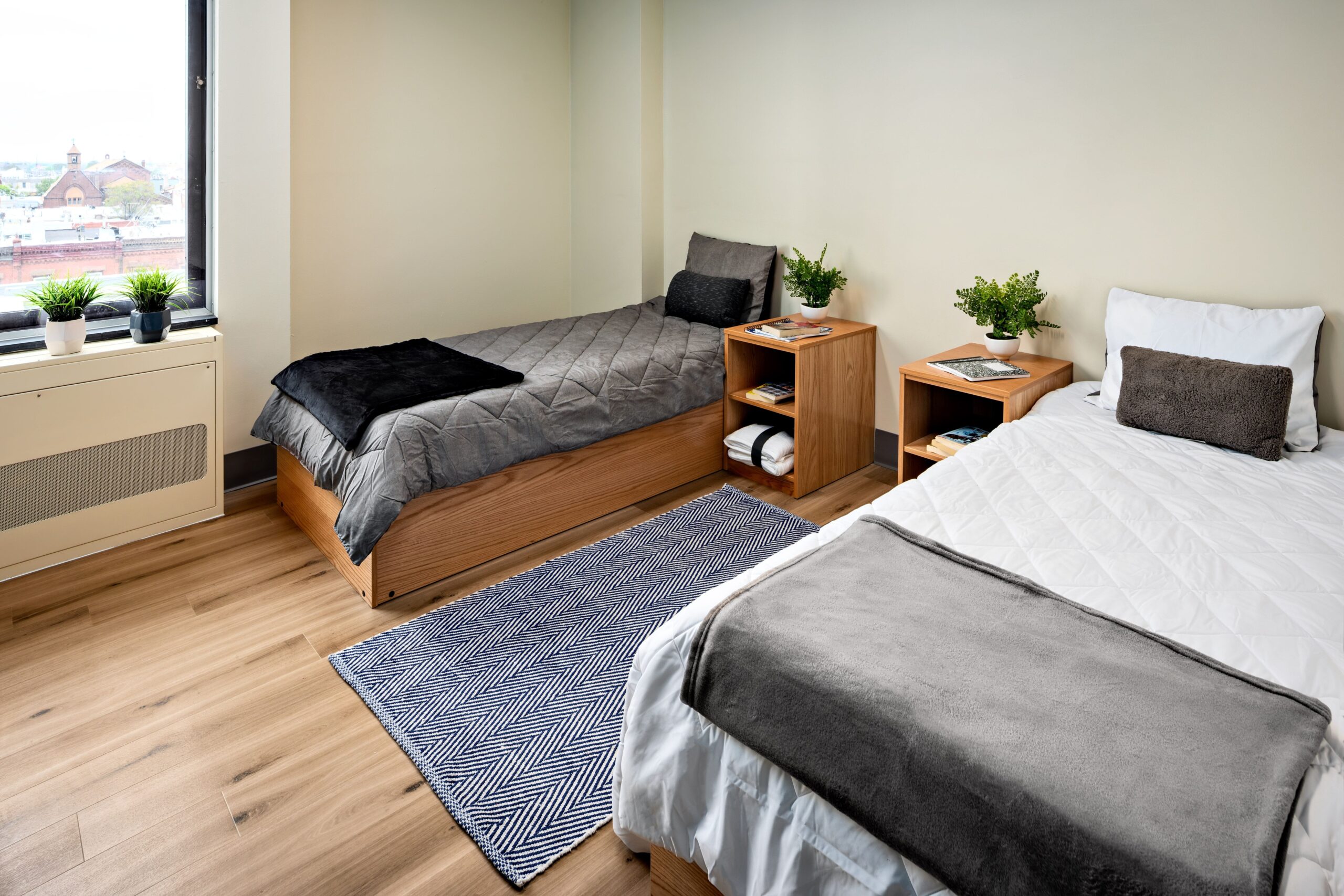 A room with an open window and two single beds for guests or inpatients.