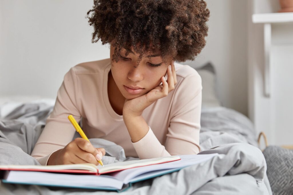 Young adult woman writing in her journal.