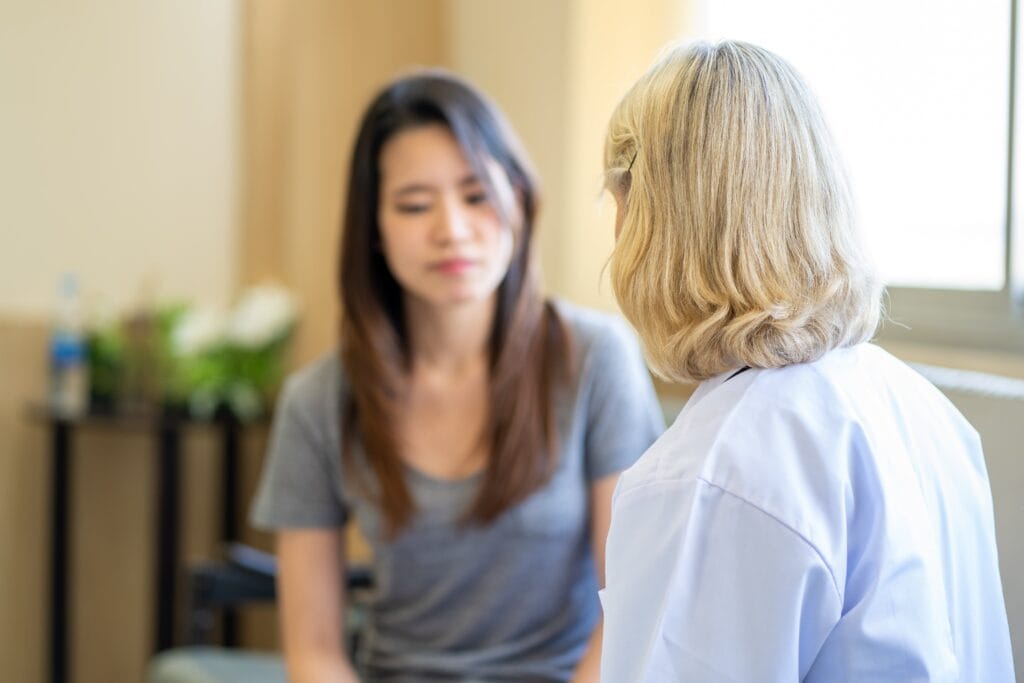 Young adult woman speaking to a mental health professional.