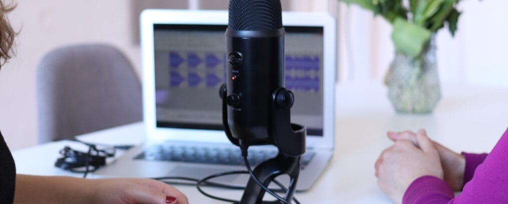 microphone sitting in front of two women. computer recording voices