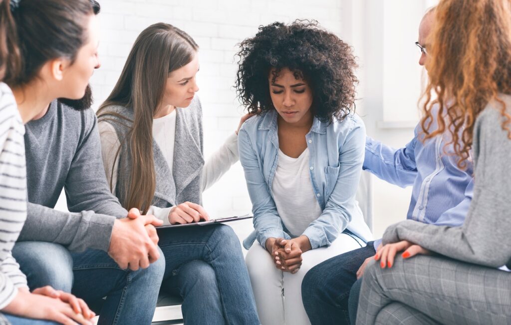 Young adult woman participating in group therapy.
