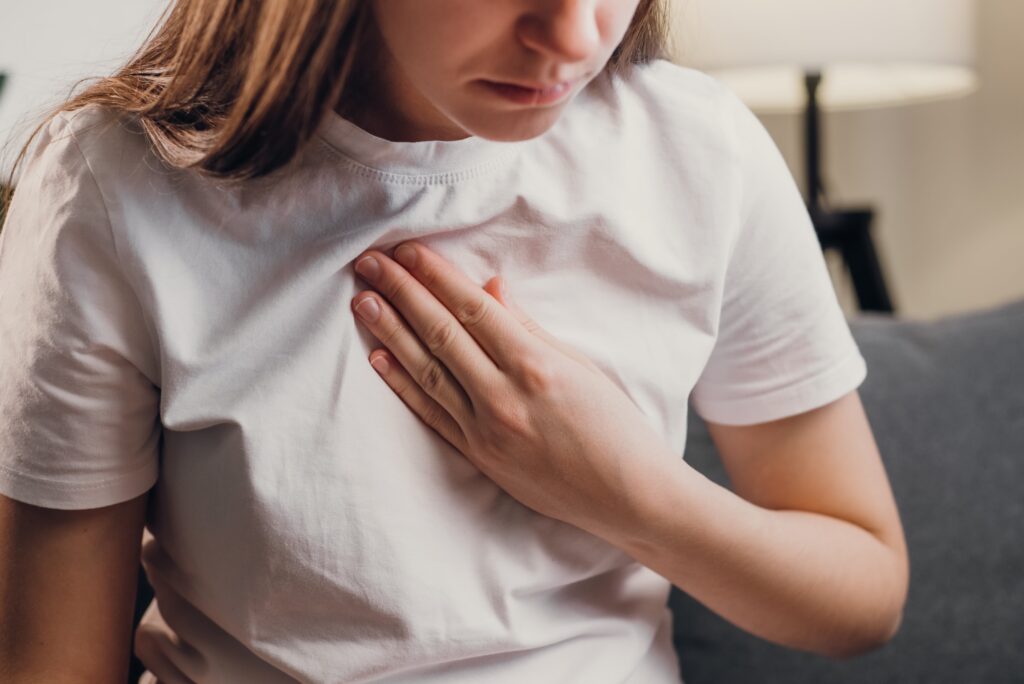 Woman holding her chest during a panic attack.