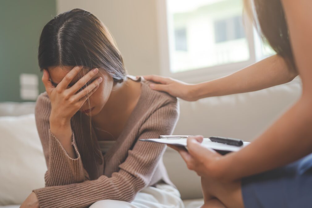 Young woman being comforted during a therapy session.