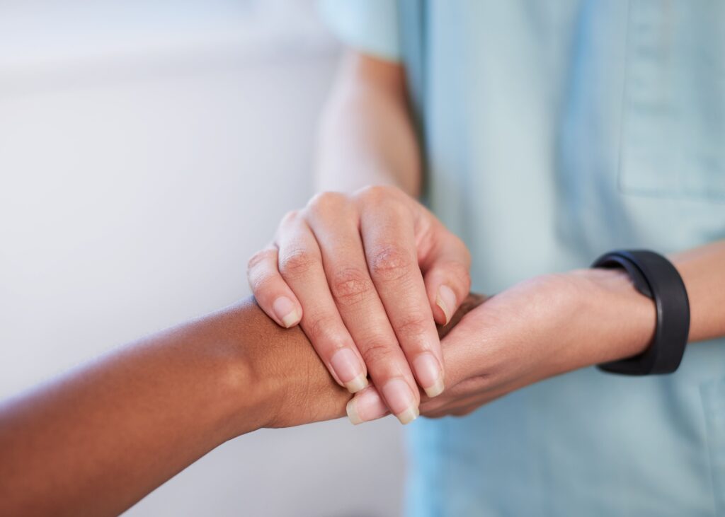 Mental health professional holding the hand of a patient.