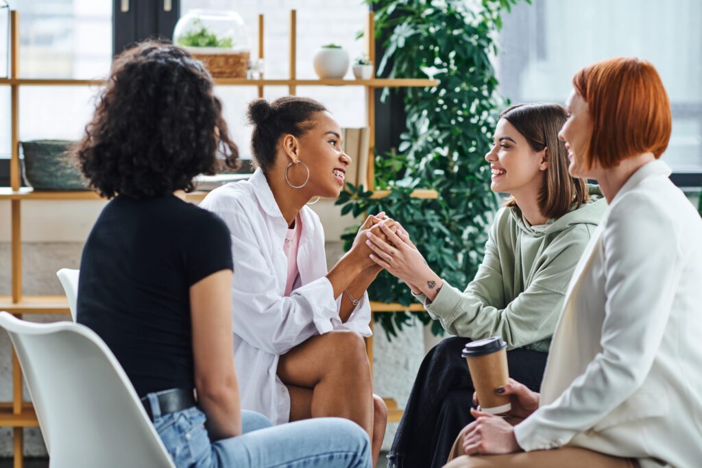 Group of young adult women talking to each other in a group therapy session.