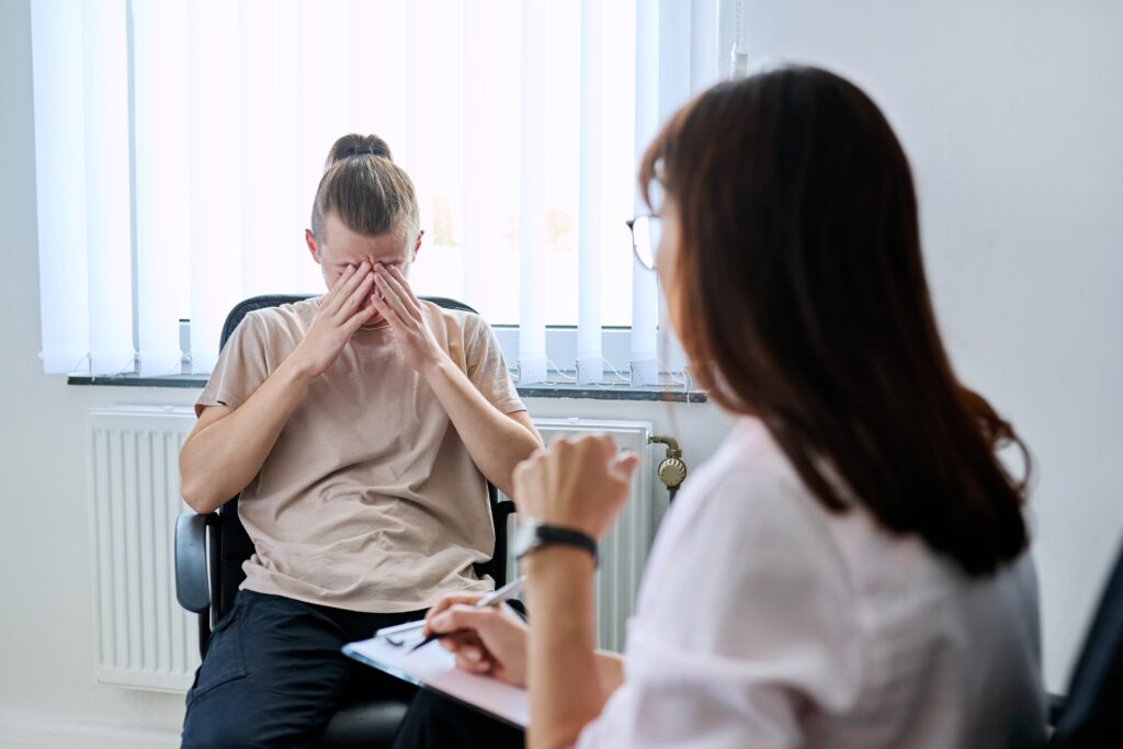 Young adult in a therapy session with a mental health professional.