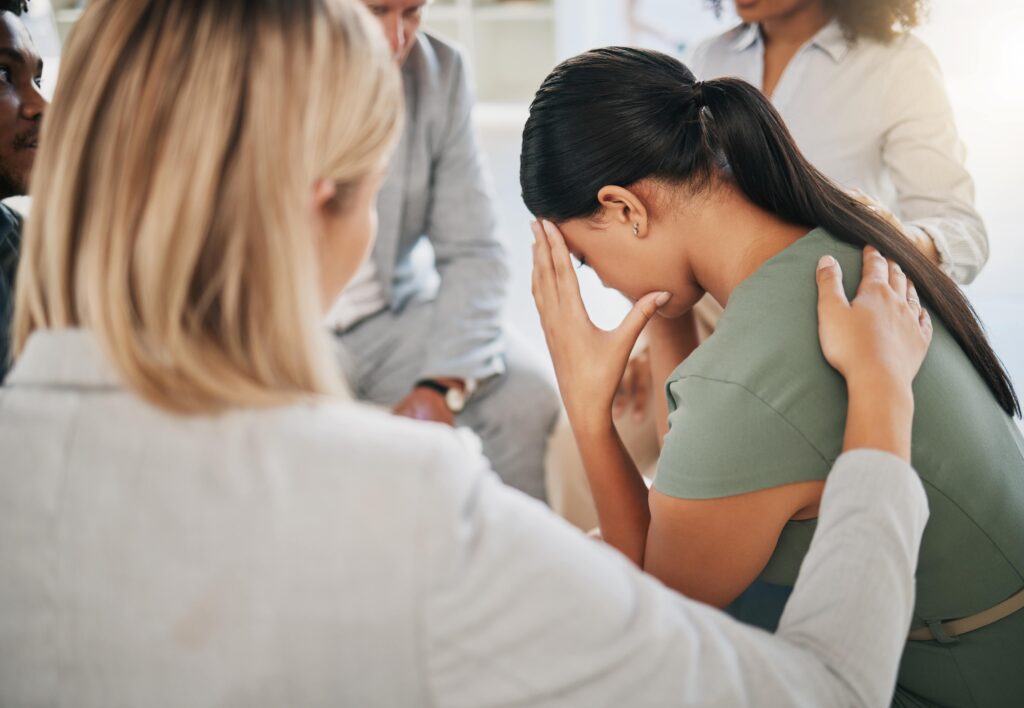 Mental health professional comforting a woman dealing with grief after suicide.