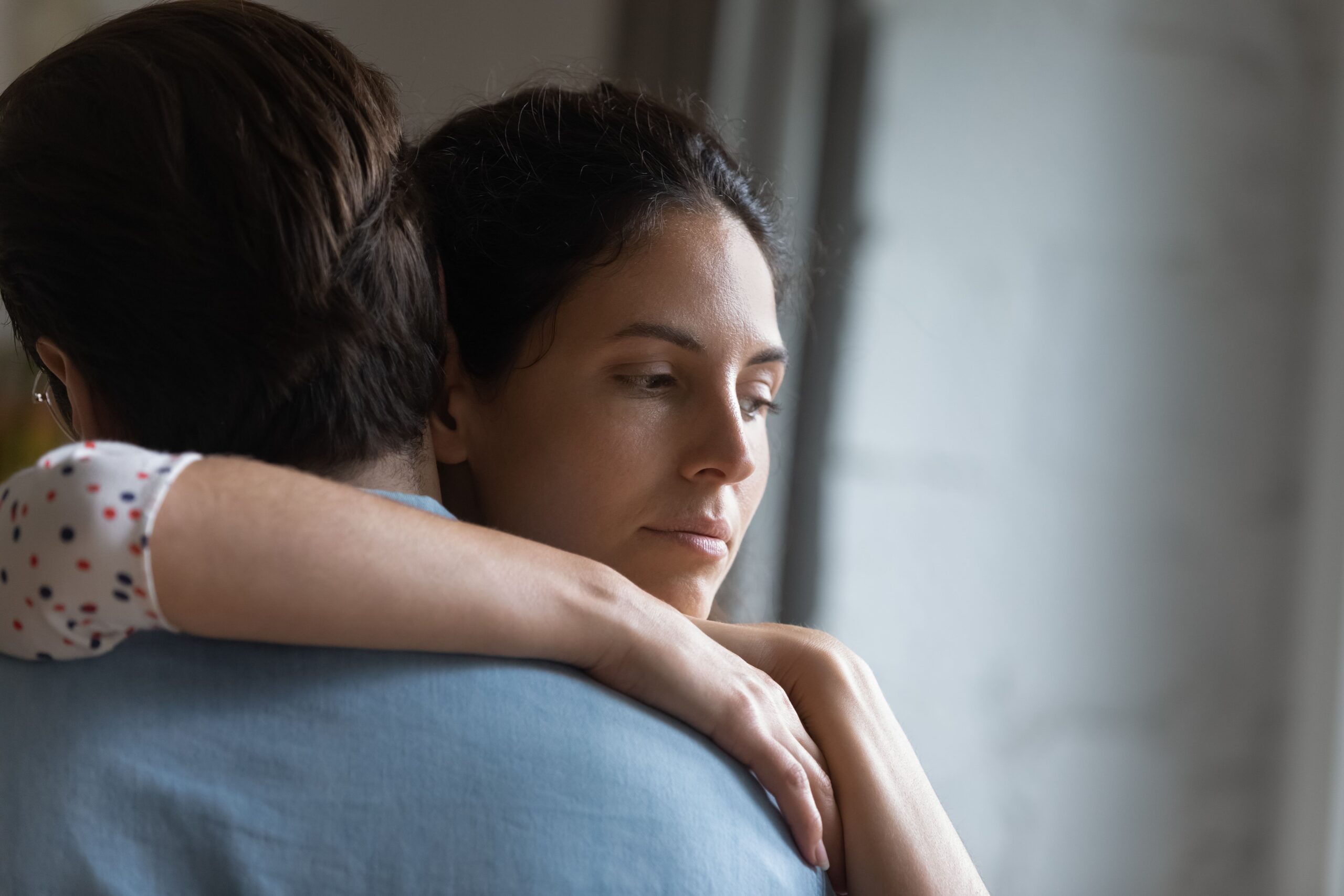 Young woman being comforted by a friend.