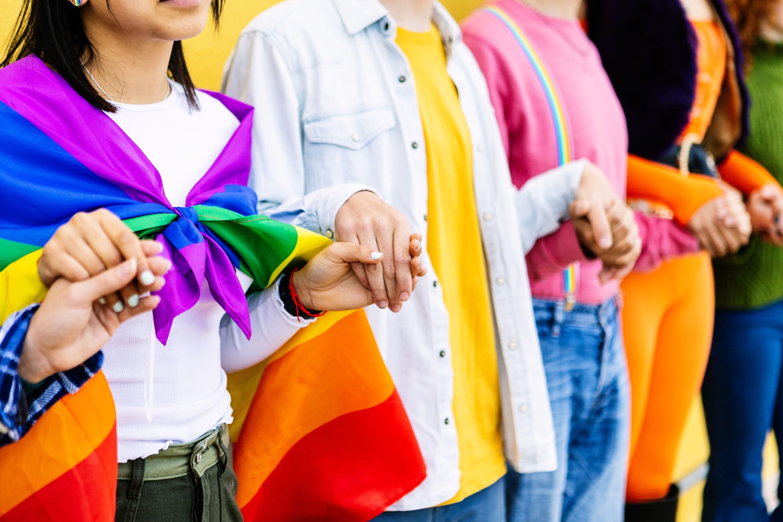 Group of young adults holding hands and supporting the LGBTQ+ community.