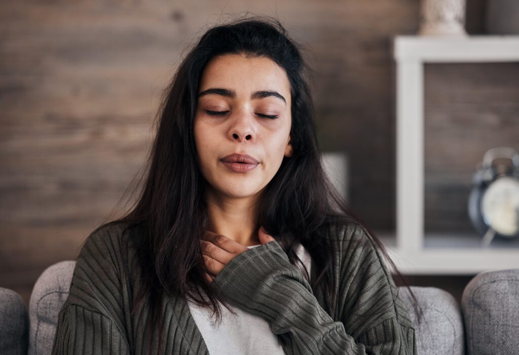 Woman practicing breathing exercises at her desk.
