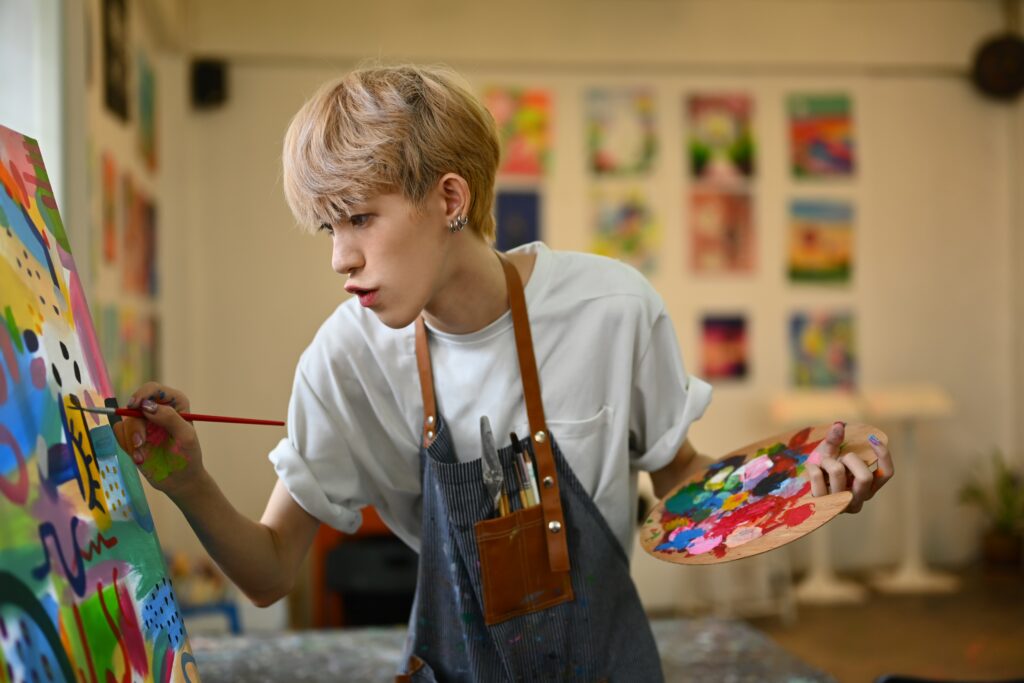 Young adult painting in an art studio.