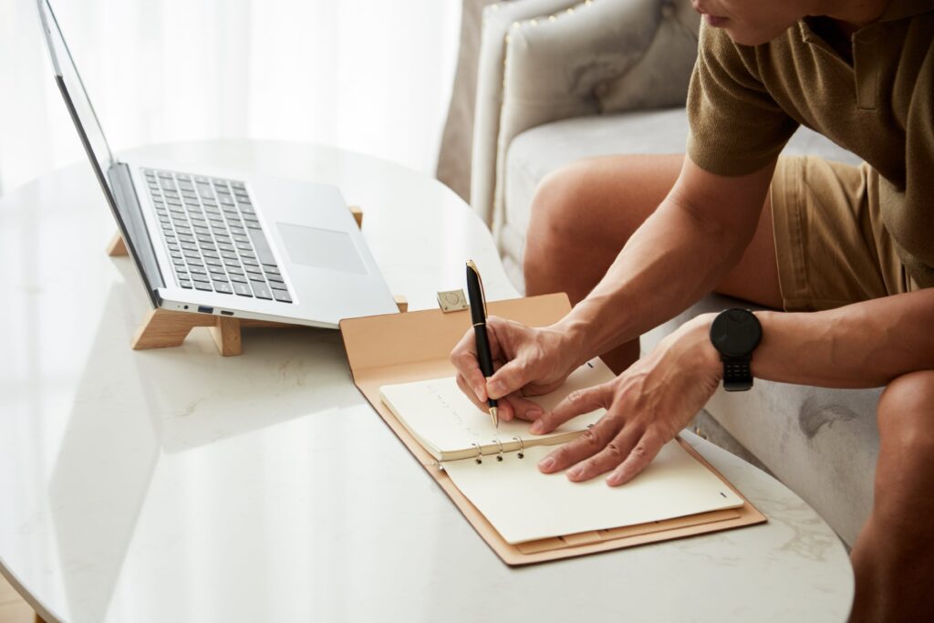 Individual writing in a daily planner.