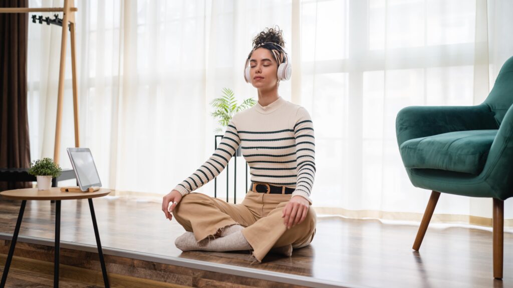 Adult woman meditating with headphones.