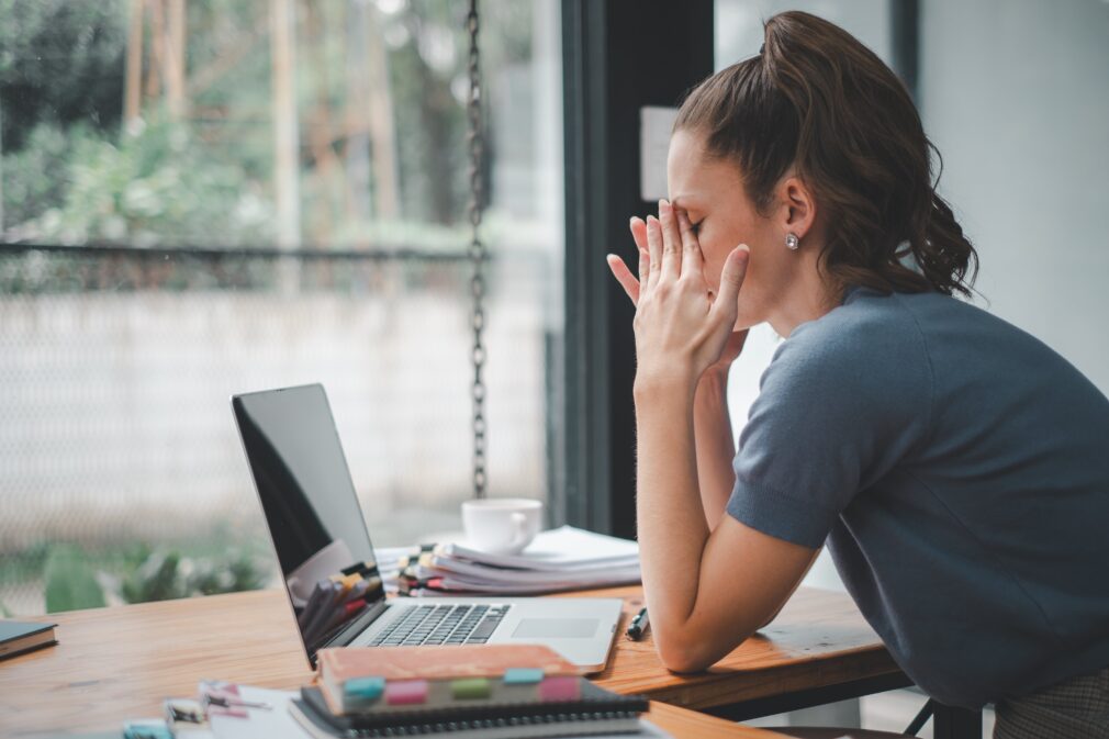 Woman sitting at desk stressed.