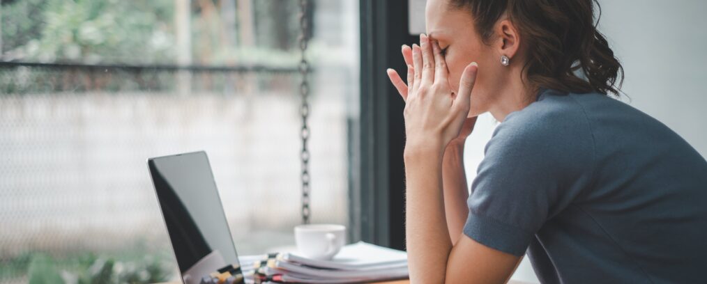 Woman sitting at desk stressed.