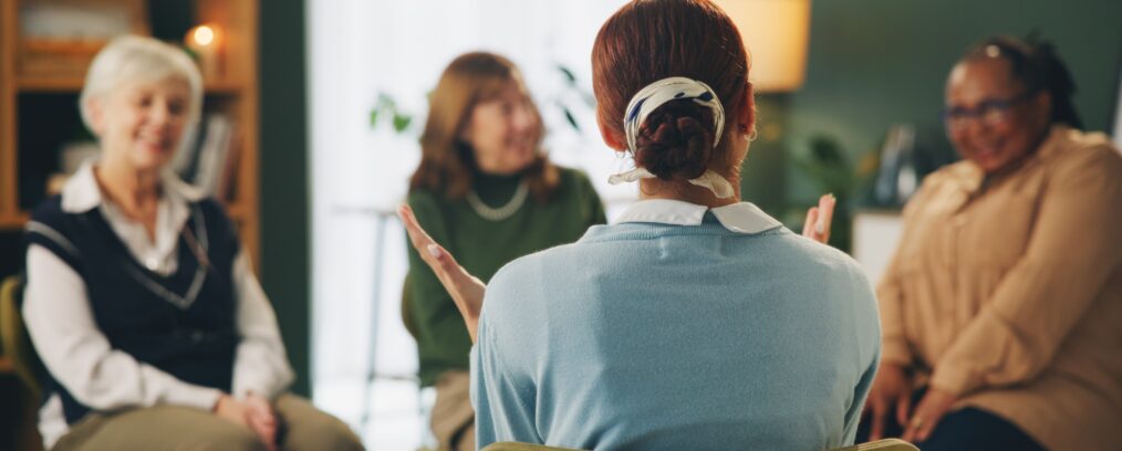 Mental health therapist talking to a group of individuals.
