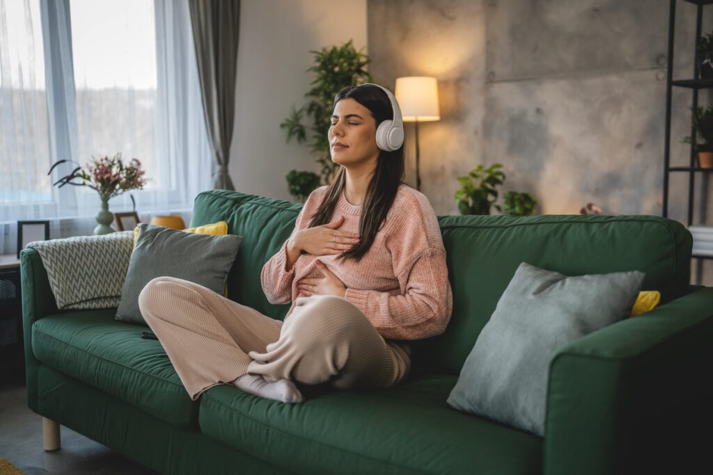 Young adult woman meditating with headphones.