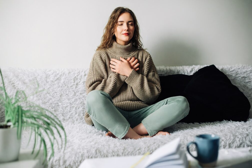 Woman meditating in her room.