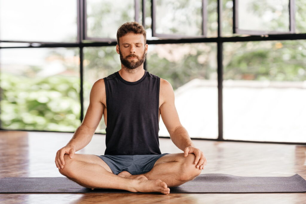 Adult man meditating and practicing breathing exercises.