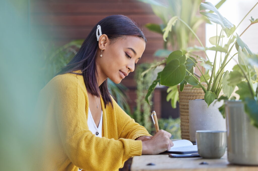 Young adult journaling at her desk.