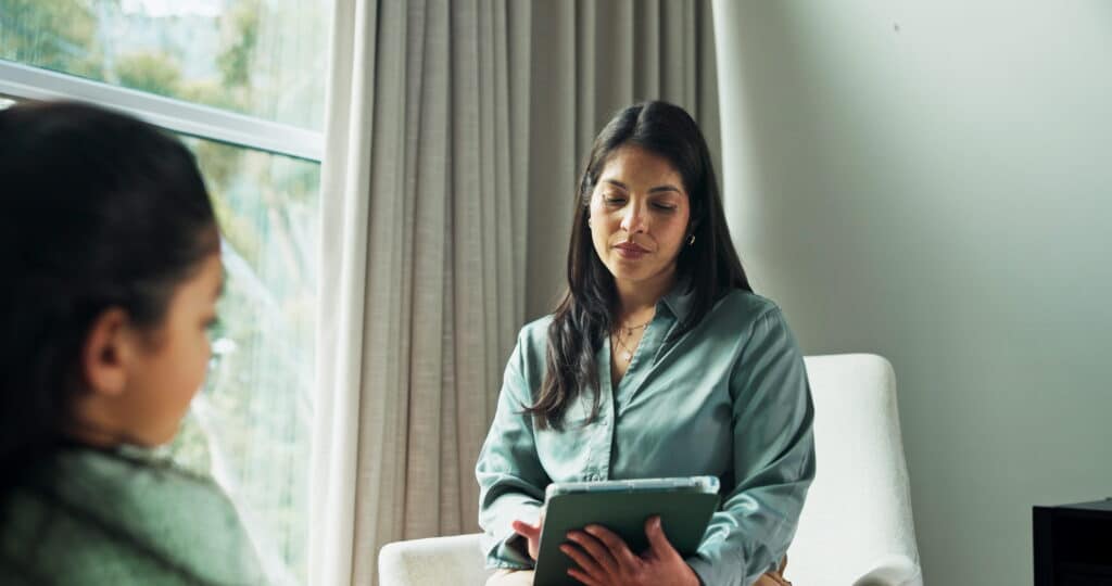 Mental health professional speaking to an individual in a therapy session.