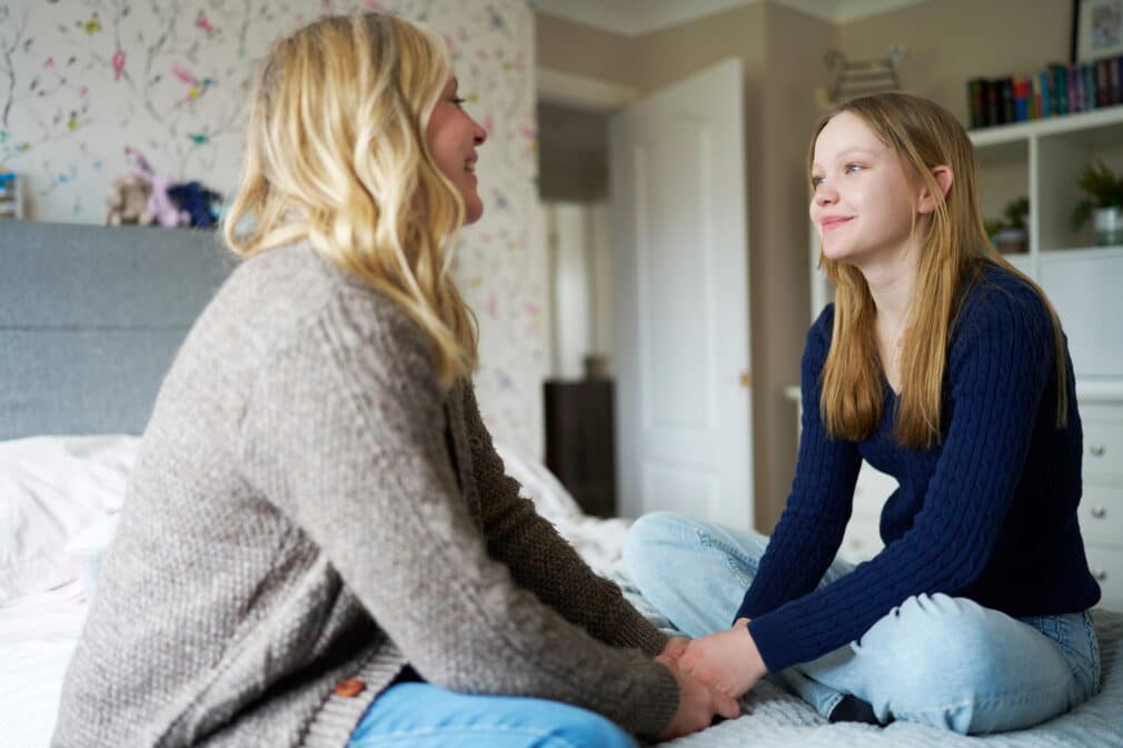 Teenage girl talking to her mother at home.