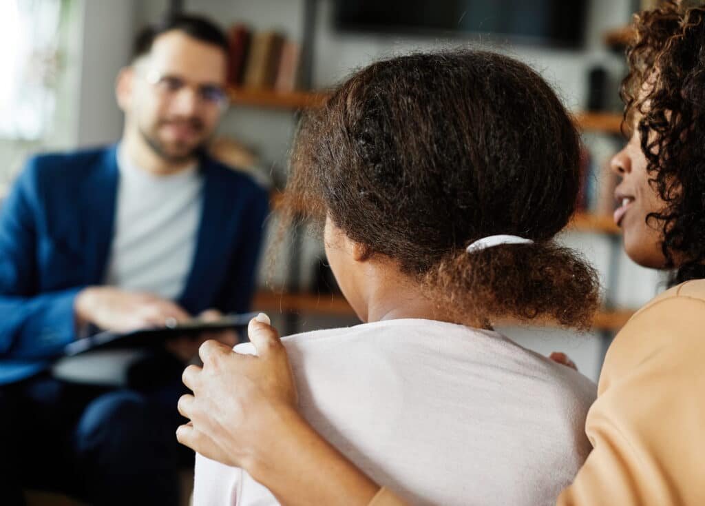 Mother and daughter talking to a mental health professional.
