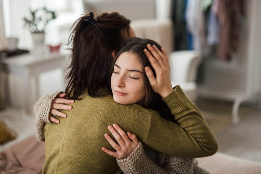 Mother hugging her daughter.