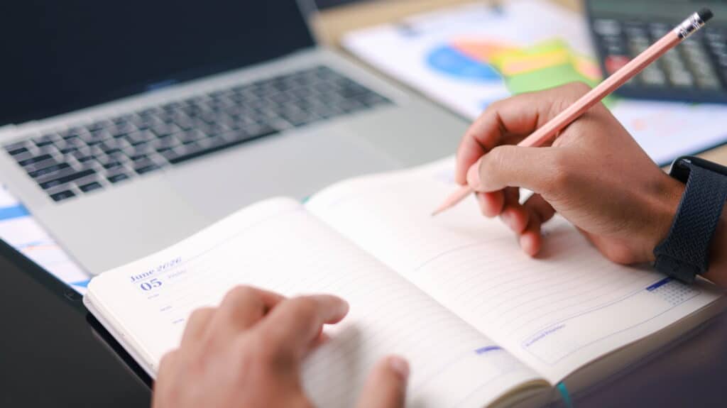 Student writing in a daily planner.